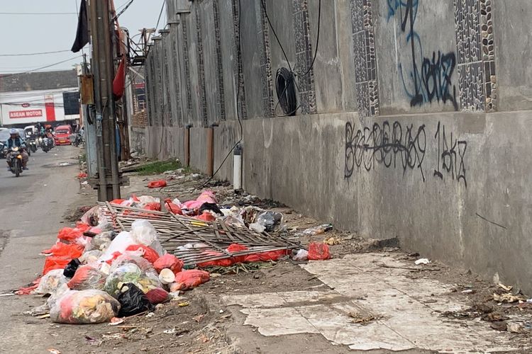 Kondisi trotoar di Pasar Induk Cibitung, Kabupaten Bekasi, Senin (5/6/2023). Terlihat dari pandangan mata, masih banyak sampah yang berserakan. Sampah didominasi plastik rumah tangga, terlihat ada yang membuat pagar kayu di tempat pembuangan sampah (TPS) liar tersebut.