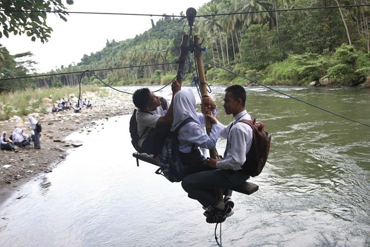 Beberapa pelajar menyeberang dengan tali penyeberangan darurat di Sungai Ranteangin, Desa Maroko ke Desa Tinokari, Wawo, Kolaka Utara, Sulawesi Tenggara, Jumat (28/7). Warga di Kecamatan Wawo hanya mengandalkan tali penyeberangan darurat untuk ke rumah dan ke kebunnya.