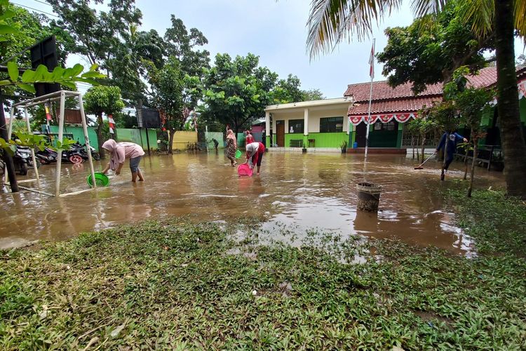 Banjir yang menggenangi halaman Madrasah Ibtidaiyah (MI) Nurul Islam di Jalan Pramuka, Kelurahan Grogol, Kecamatan Limo, Depok, Senin (22/8/2022), dimanfaatkan pihak sekolah untuk ajang perlombaan menangkap ikan.