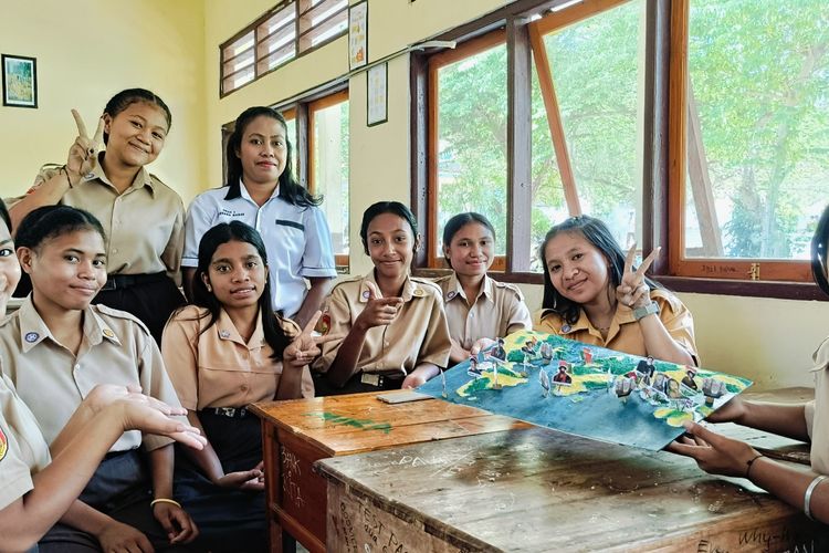 Elisabet Sabu Sogen (33) guru Sejarah di Sekolah Menengah Atas (SMA) Negeri 1 Adonara Barat, Kabupaten Flores Timur, Nusa Tenggara Timur (NTT), bersama siswa-siswinya dalam kegiatan pembelajaran materi dengan menggunakan media grafis  bekas.