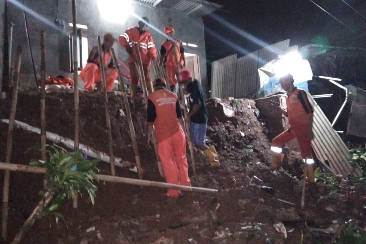 Petugas PPSU sedang membersihkan puing longsoran dan memasang turap sementara bagian depan rumah milik seorang warga di Jalan Agung Raya 2 Gang Swadaya 2 RT 005/04, Lenteng Agung, Jagakarsa, Jakarta, Kamis (13/8/2020) yang longsor pukul 16.00 WIB.
