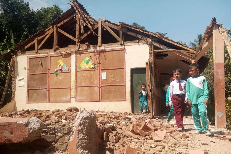 Sejumlah siswa SDN Pancawangi Cilaku, Kabupaten Cianjur, Jawa Barat melintasi puing-puing bangunan kelas mereka yang ambruk. Para siswa pun terpaksa belajar di lapang beralaskan terpal.