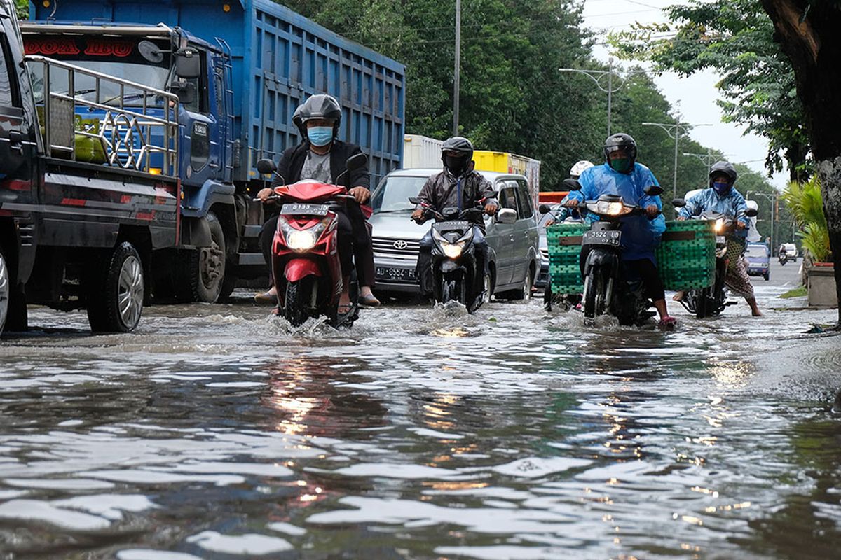 Sejumlah kendaraan melintasi genangan air saat banjir di jalur Pantura kota Kendal, Jawa Tengah, Senin (8/2/2021). Sejak dua hari lalu jalur Pantura di kota Kendal tergenang air sehingga mengakibatkan lalu lintas tersendat, selain itu banjir juga menggenangi puluhan desa di kabupaten Kendal.