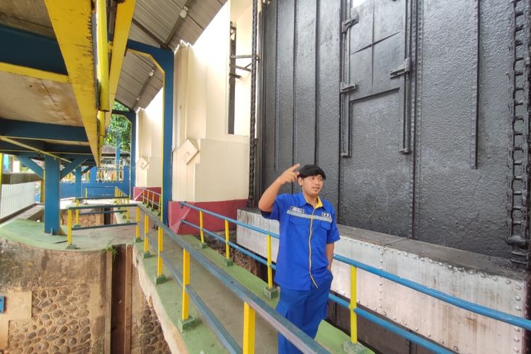 Elang Bayu (22), operator Pintu Air Manggarai, Jakarta saat menjelaskan mengenai sejarah dan fungsi pintu air Manggarai, Jumat (25/11/2022).