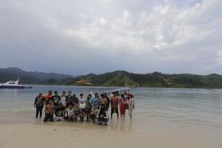 Para wisatawan berfoto sebelum meninggalkan Pulau Setan di Kawasan Wisata Mandeh, Kecamatan Koto XI Tarusan, Kabupaten Pesisir Selatan, Sumatera Barat. Pulau Setan terletak di sebelah barat Sungai Pisang dan sebelah timur Pulau Pasumpahan. Untuk menuju pulau ini, wisatawan dapat menempuh dengan perahu dari Tempat Pelelangan Ikan Carocok Tarusan.