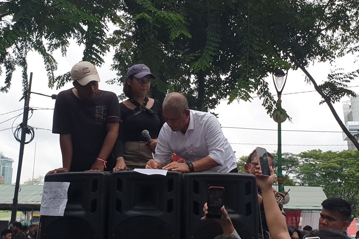 Ketua DPRD Sumut Sutarto saat menandatangani surat berisi tuntutan massa aksi di depan Kantor DPRD Sumut pada Jumat (23/8/2024). 