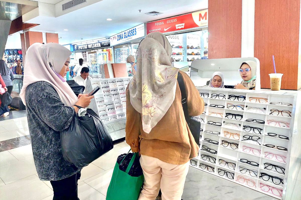 Pengunjung pusat perbelanjaan Senen Jaya 1 dan 2 sedang mencoba kacamata.