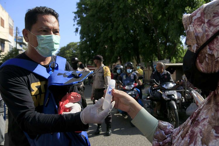 Komunitas etnis tionghoa yang tergabung dalam Yayasan Hakka Aceh membagikan masker dan hand sanitizer kepada pedagang kaki lima dan warga di pasar Peunayong,Kota Banda Aceh. Rabu (08/04/2020). 5000 masker dan hand sanitizer ini dibagikan secara geratif kepada pedagang kaki lima dan warga yang tidak memilki masker saat beraktifitas diluar rumah ini dilakukan sebagi aksi berbagi sesama untuk mencegah penyebaran wabah virus corona di Aceh, seperti himbauan pemerintah masyarakat wajib menggunkan masker saat melakukan aktivitas di luar rumah.