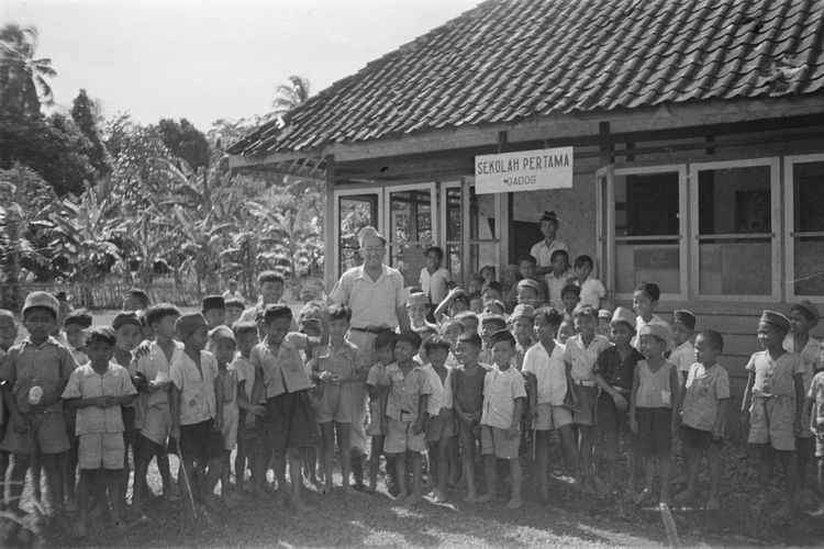 Seorang pria Belanda berfoto bersama anak-anak sekolah dasar di Sekolah Pertama Gadog, Jawa Barat, 15 November 1947