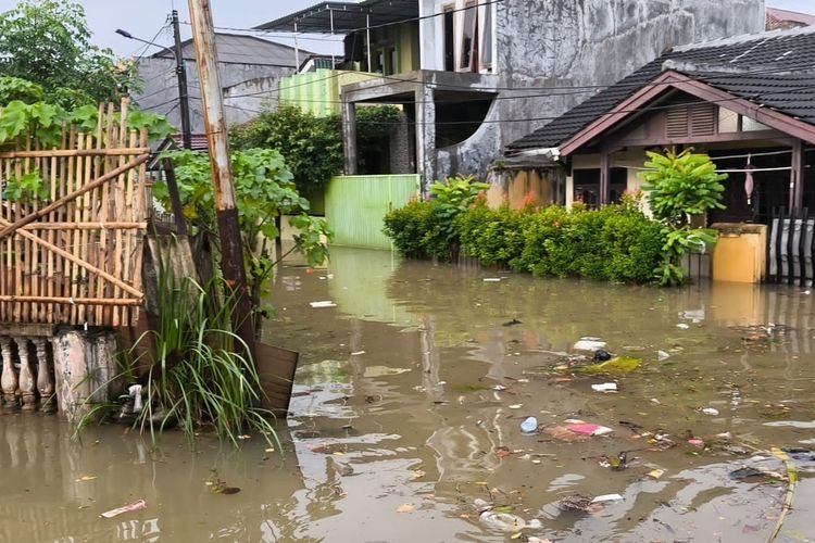 Kondisi banjir di Perumahan Pinang Griya Permai, Pinang, Kota Tangerang, yang banjir karena tanggul Kali Angke jebol pada Jumat (23/1/2026). Terlihat banyak sampah ikut tergenang banjir.