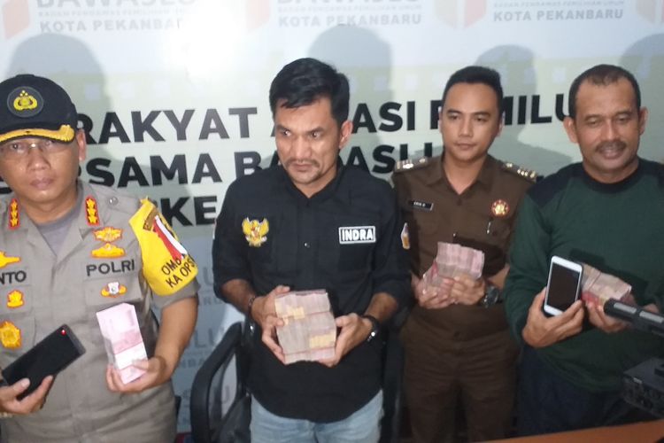 Bawaslu dan Polresta Pekanbaru melihatkan barang bukti uang ratusan juta yang diamankan dari empat orang terduga pelaku politik uang, saat konferensi pers di Kantor Bawaslu Pekanbaru, Riau, Selasa (16/4/2019). 