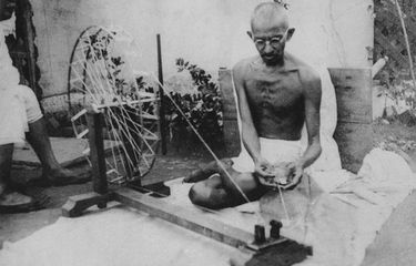 Mahatma Gandhi sedang memintal kain. Foto ini diambil pada tahun 1920-an.