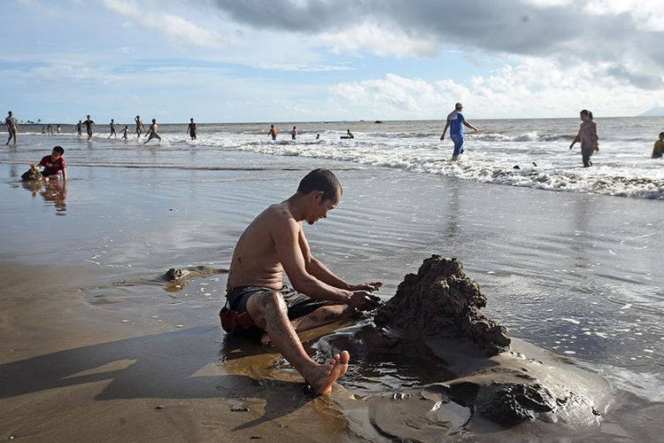 Sejumlah wisatawan memanfaatkan waktu usai berlebaran dengan rekreasi di Pantai Sambolo Anyer, Serang, Banten, Selasa (26/5/2020). Meski Pemda setempat telah menutup semua tempat wisata hingga 3 Juni 2020 untuk mencegah sebaran Covid-19, namun sejumlah pengelola wisata pantai di kawasan Anyer dan Carita tetap menerima pengunjung walau tak seramai libur Lebaran tahun lalu.