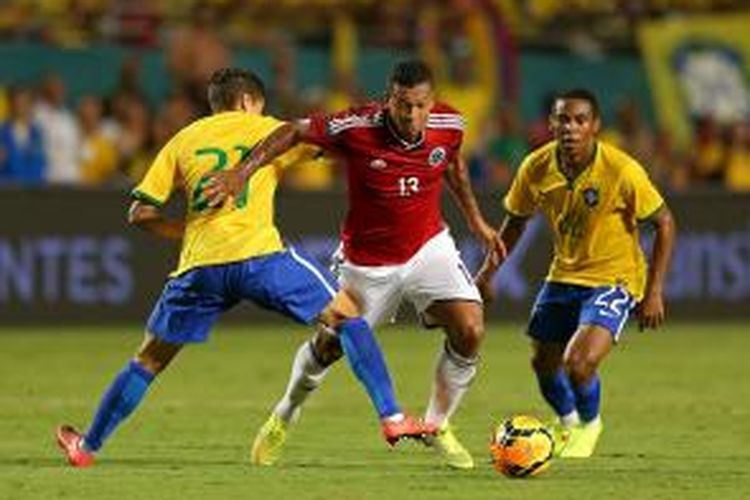 Gelandang Kolombia Fredy Guarin (tengah) berusaha melewati adangan gelandang Philippe Coutinho (kiri) dan Victor, pada laga persahabatan, di Sun Life Stadium, Miami, 5 September 2014.