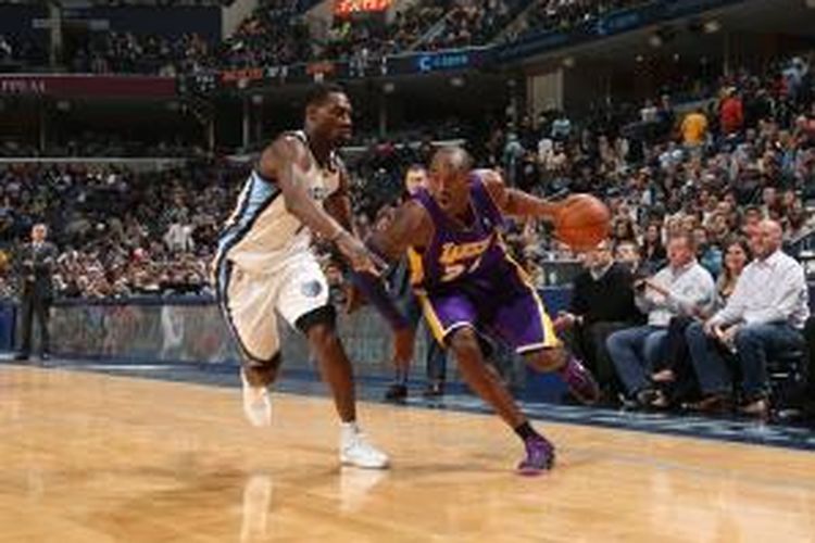 Pebasket Los Angeles Lakers, Kobe Bryant (kanan) mencoba melewati pemain Memphis Grizzlies pada laga lanjutan kompetisi NBA di FedExForum in Memphis, Tennessee, Selasa (17/12/2013).