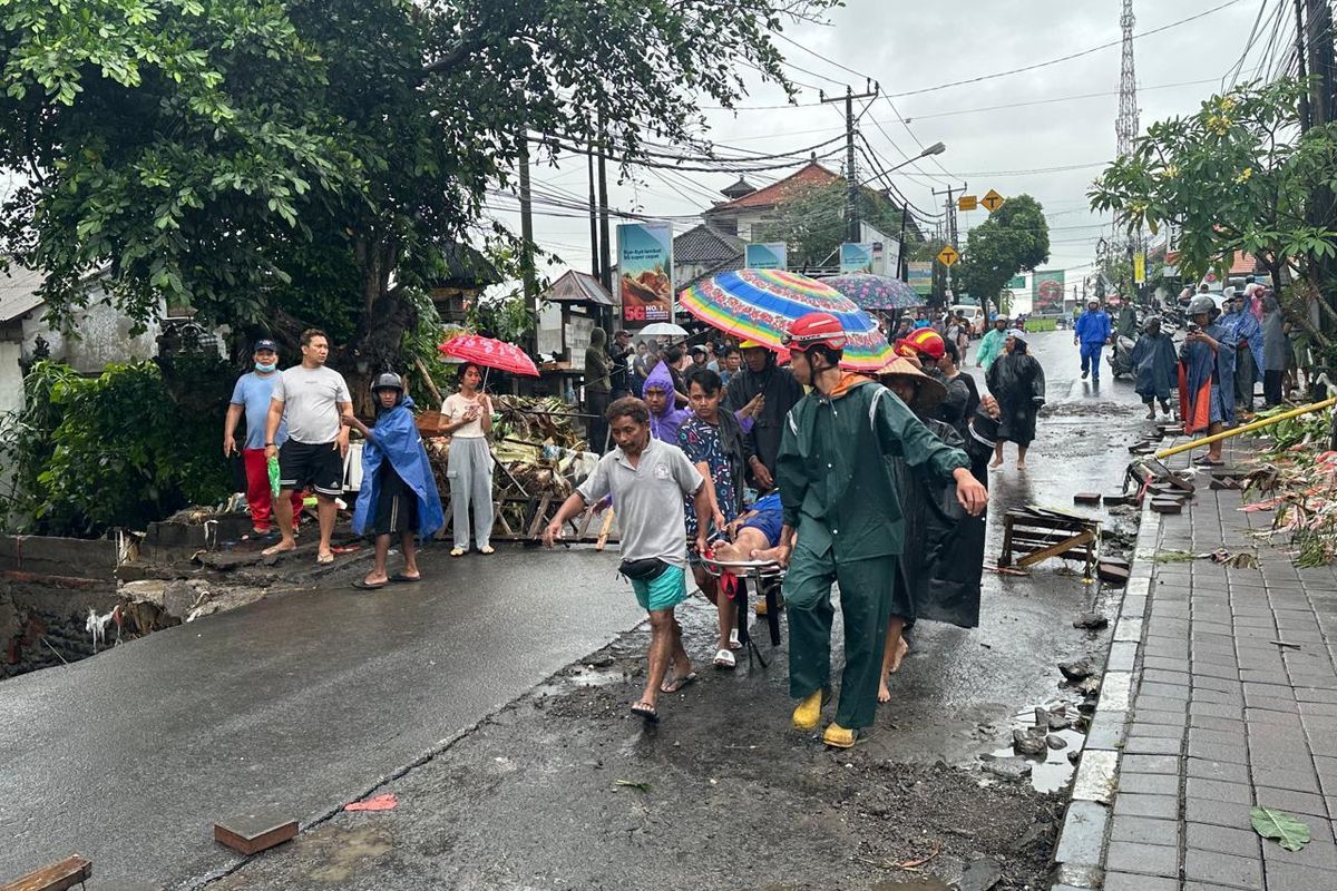 Warga saat mengevakuasi korban mobil terseret banjir di Jalan Utama Pasar Pengosari, Kelurahan Kerobokan, Kecamatan Kuta Utara, Kabupaten Badung, Provinsi Bali, pada Rabu (10/9/2025).