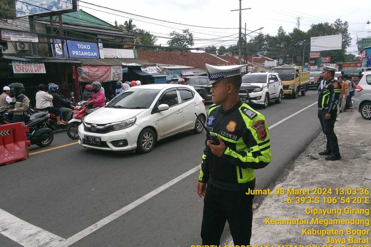 Anggota satlantas Polres Bogor sedang melakukan pengaturan arus kendaraan saat diterapkannya ganjil genap di Puncak Bogor, Jawa Barat, Jumat (8/3/2024).