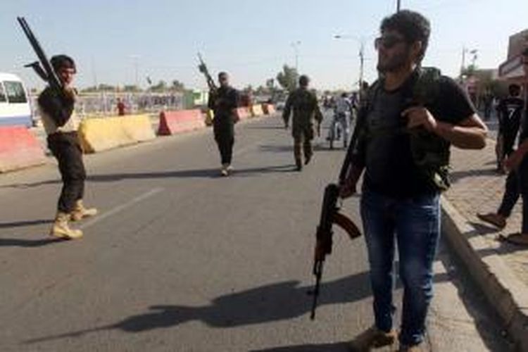 Warga di Baghdad membawa senjata saat mereka berkumpul untuk menunjukkan kesiapan untuk bergabung dengan pasukan keamanan Irak dalam perang melawan militan Jihad yang telah mengambil alih beberapa kota di utara Irak, 16 Juni 2014.