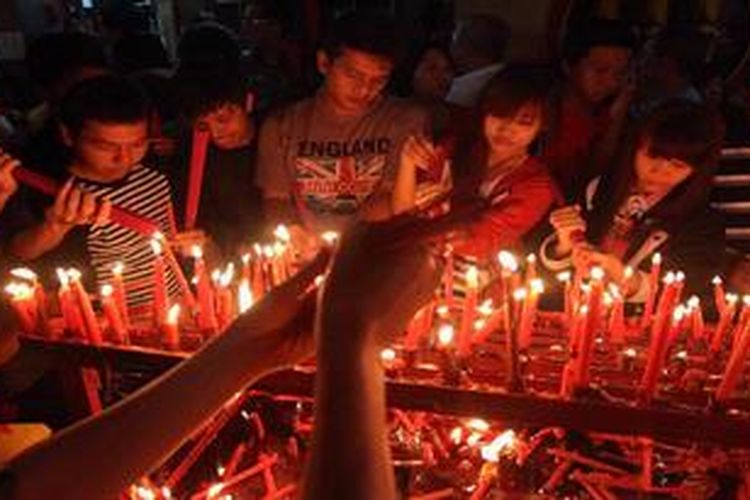 Warga membakar dupa untuk bersembahyang di Kelenteng Boen Tek Bio, Pasar Lama, Tangerang, Banten, Minggu (10/2/2013) dini hari. Dari sore selama 24 jam ribuan warga keturunan Tiong Hoa mendatangi kelenteng untuk bersembahyang menyambut Tahun Baru Imlek.
