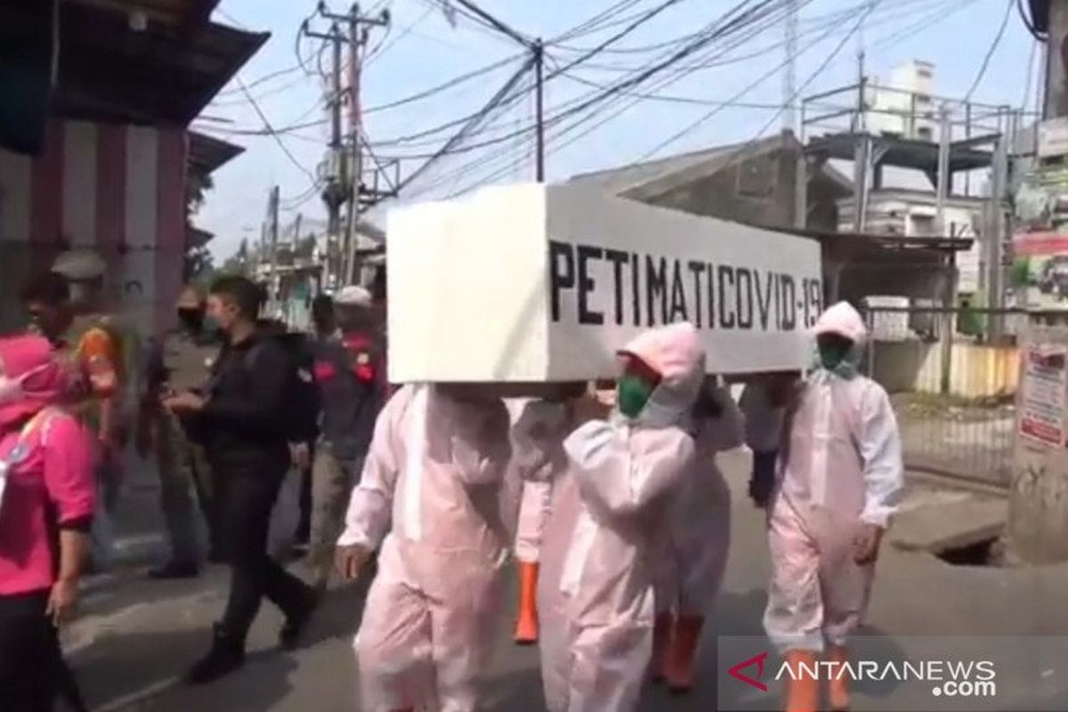 Petugas gabungan di Kecamatan Cakung, Jakarta Timur, berkeliling perkampungan padat hunian dengan mengarak peti jenazah COVID-19 dalam rangka penertiban protokol kesehatan, Selasa (8/9/2020). 