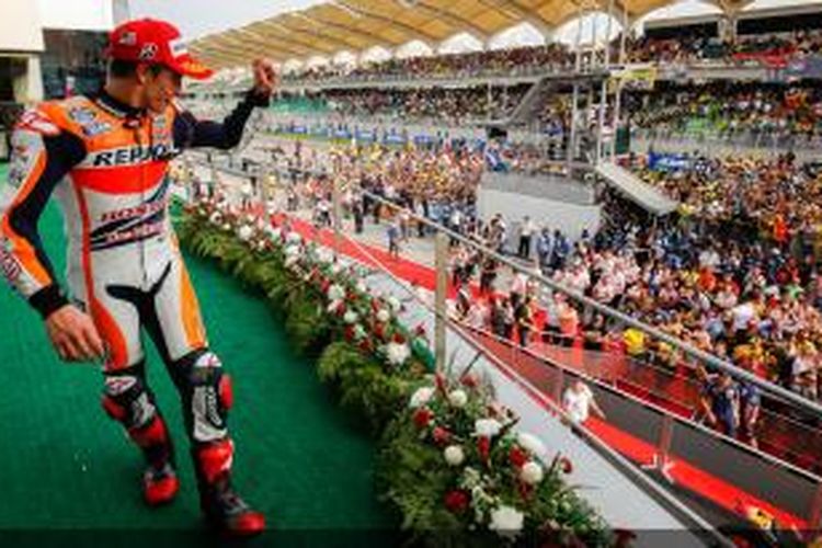 Pebalap Repsol Honda asal Spanyol, Marc Marquez, merayakan kemenangan di atas podium Sirkuit Sepang setelah finis pertama pada GP Malaysia, Minggu (26/10/2014).