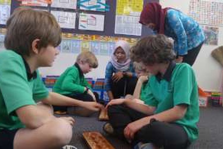 Anak-anak usia sekolah dasar di Turner School mengikuti pelajaran Bahasa Indonesia melalui permainan tradisional congklak. Dyah Candra Arbiningrum dan rekannya, guru dari Pangkalan Bun, Kalimantan Tengah, ikut mengajar sebagai guru pendamping saat mengikuti program Bridge.