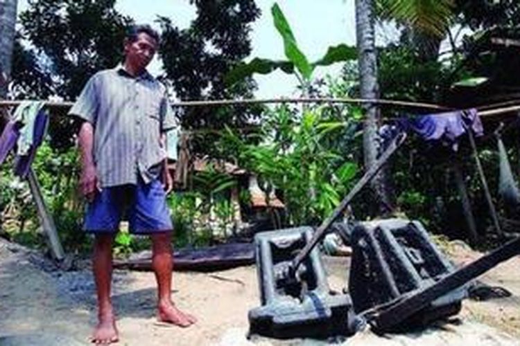 Suwardi dengan bagian terakhir Kapal Berouw yang dia temukan di Lembah Sungai Kuripan, Kampung Berouw, Kelurahan Negeri Olok Gading, Teluk Betung, Bandar Lampung, Kamis (11/8/2011). Di lembah sungai tersebut, ia mendapati sisa bagian dari kapal yang hanyut terbawa tsunami dari meletusnya Krakatau tahun 1883. Kampung di lembah itu kemudian diberi nama Kampung Berouw.