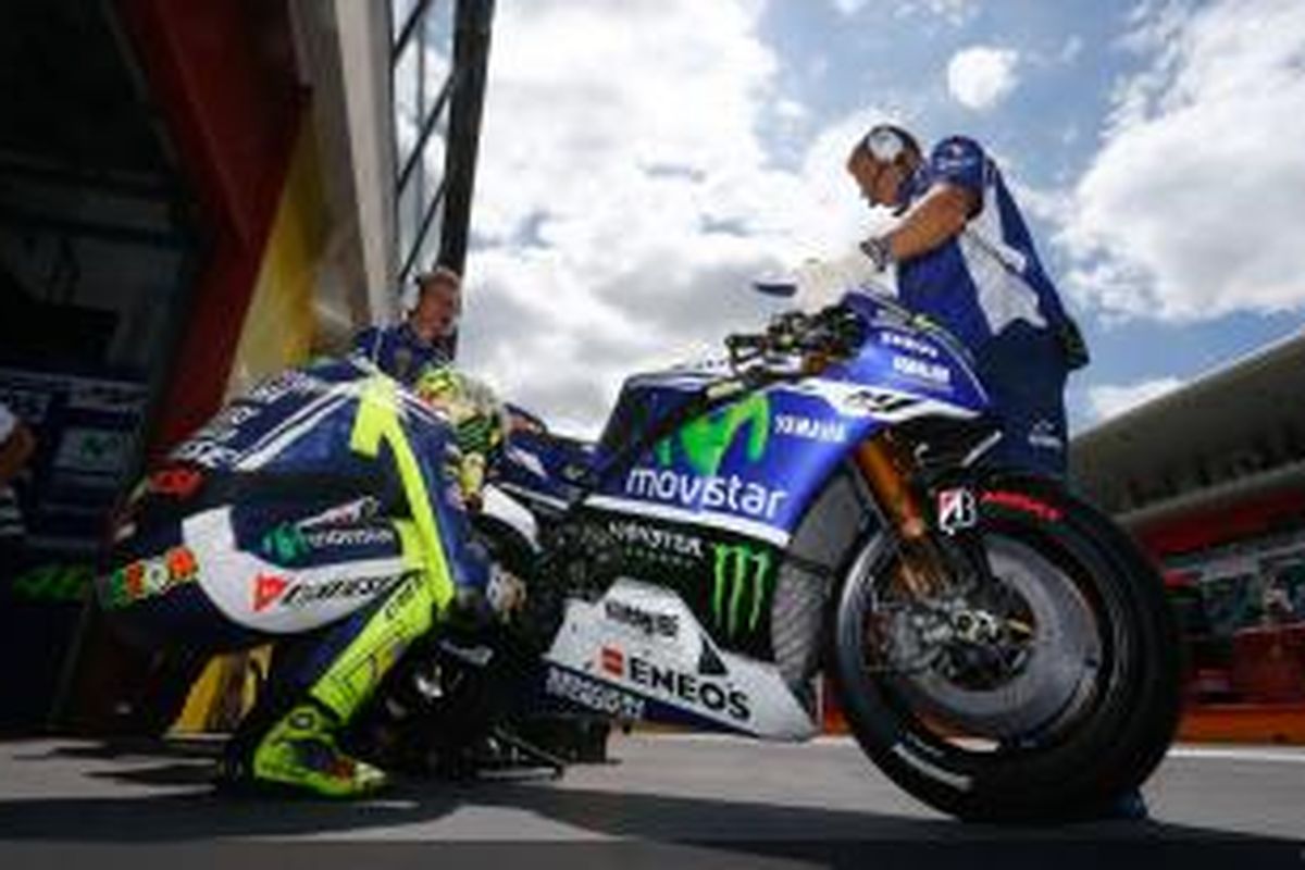 Pebalap Movistar Yamaha asal Italia, Valentino Rossi, memperhatikan motornya saat sesi kualifikasi GP Italia di Sirkuit Mugello, Sabtu (31/5/2014).