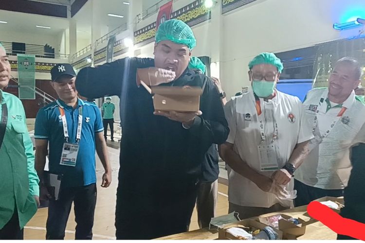Menteri Pemuda dan Olahraga, Dito Ariotedjo, makan nasi boks saat meninjau pusat distribusi pengemasan konsumsi Pekan Olahraga Nasional (PON) XXI di Politeknik Pariwisata (Poltekpar) Negeri Medan, Jumat (13/9/2024).