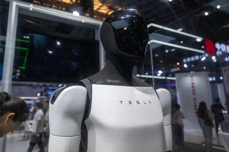 Robot humanoid Tesla Optimus. Robot yang dikembangkan oleh perusahaan milik Elon Musk ini menjadi saingan R1 buatan China karena kemampuannya yang hampir sama yaitu bisa melakukan tugas-tugas sederhana, seperti membawa gelas, menyortir balok berwarna, melakukan pose yoga, hingga memainkan permainan batu, gunting, kertas dengan manusia.