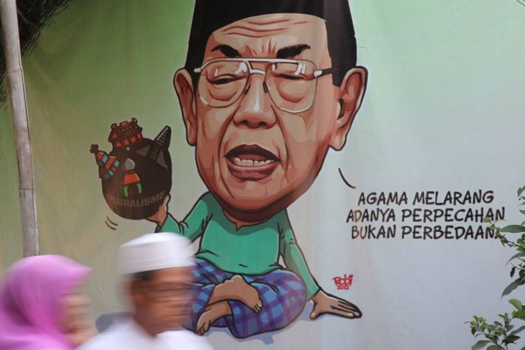 Warga melintas di depan spanduk yang mengutip pernyataan mantan Presiden RI KH Abdurrahman Wahid (Gus Dur) di kawasan Duren Sawit, Jakarta, Minggu (10/8/2014). 