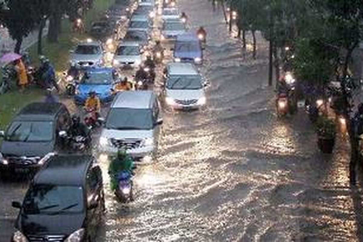 Sejumlah kendaraan bermotor melintas sebagian ruas Jalan Jendral Sudirman yang tergenang air saat hujan deras yang mengguyur Jakarta, Senin (25/10/2010). Akibat genangan air ini, arus lalu lintas di sebagian ruas jalan tersebut mengalami kemacetan, genangan ini juga menyebabkan sebagian pengguna sepeda motor masuk ke jalur cepat.