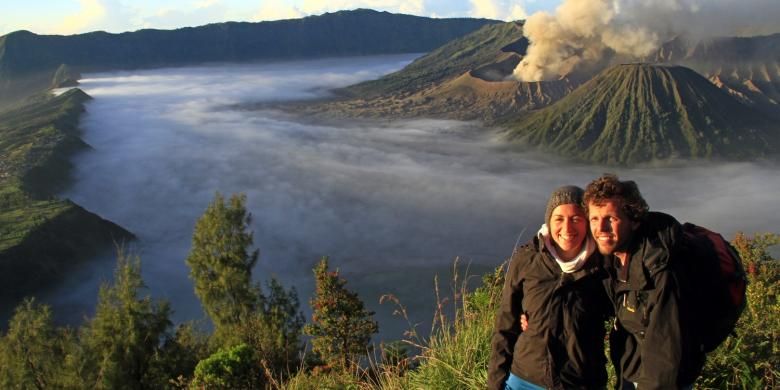 Sepasang turis asing berfoto dengan latar belakang Gunung Bromo dan Gunung Batok di Bukit Kingkong.