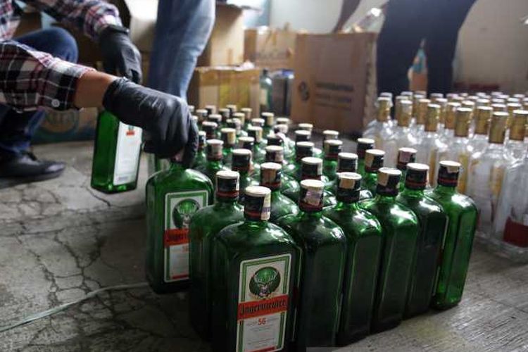 Petugas Kantor Bea Cukai Surakarta saat menyita seribuan botol kosong dan bahan minuman keras merek impor untuk dijadikan barang bukti di Kantor Bea Cukai Surakarta, Jawa Tengah, Rabu (7/7/2021). 
