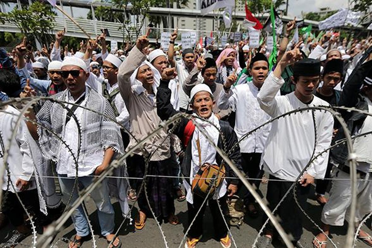 Massa Front Pembela Islam berunjuk rasa di depan Polda Metro Jaya, Jakarta, Senin (23/1/2017). Pimpinan FPI Rizieq Shihab diperiksa oleh Subdirekorat Fiskal, Moneter, dan Devisa Direktorat Reserse Kriminal Khusus Polda Metro Jaya, terkait ucapannya soal gambar palu arit di logo Bank Indonesia dalam lembaran uang rupiah.