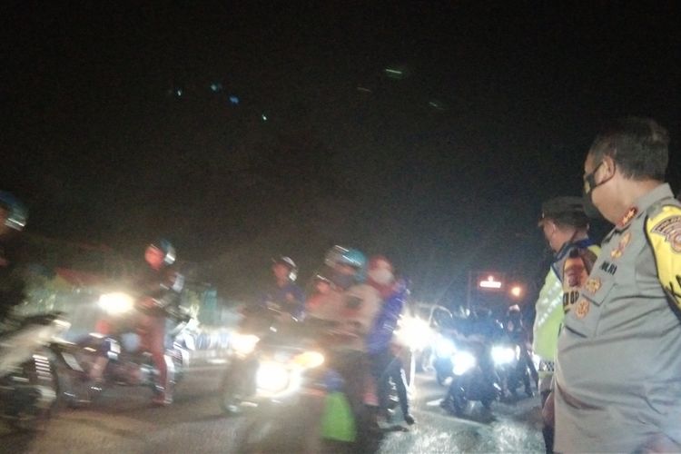 Petugas tengah mengatur arus lalu lintas di Jalan Arteri Karawang, Sabtu (1/5/2022) pukul 23.00 WIB.