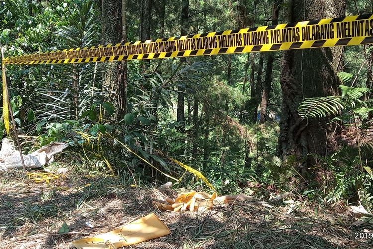 Garis polisi dipasang di lokasi penemuan mayat dalam koper di atas jurang hutan pinus, Kampung Teluk Waru RT 01/13, Desa Curug Bitung, Kecamatan Nanggung, Bogor, Jawa Barat.