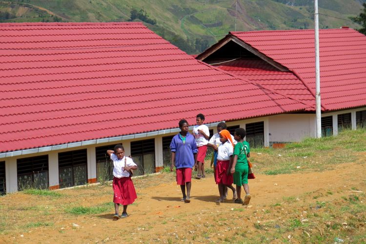 Sekelompok siswa SD Inpres Tiom berjalan pulang dari sekolahnya yang belum sepenuhnya memulai aktivitas belajar-mengajar di Kabupaten Lanny Jaya, Papua, Selasa (28/7/2015). Kabupaten pemekaran dari Jayawijaya pada tahun 2008 ini membutuhkan 200-300 guru TK/PAUD, SMP,dan SMA/SMK.