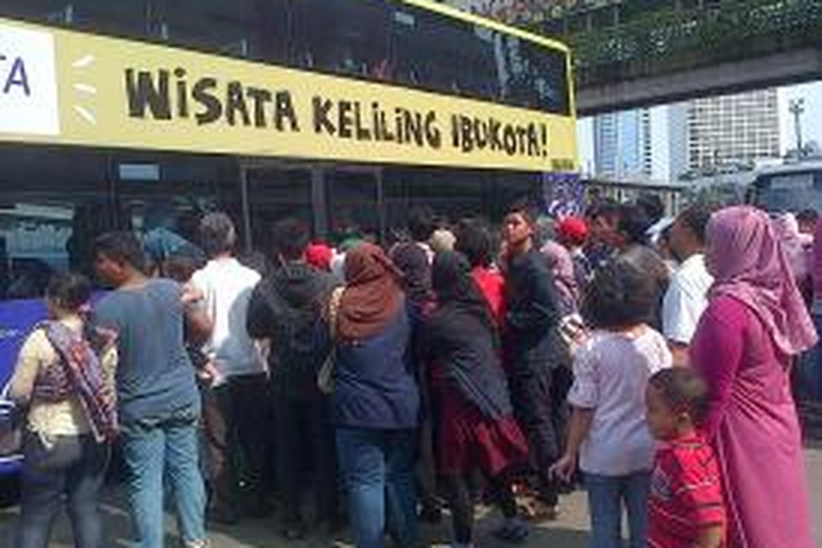 Warga mengantre untuk bisa masuk bus tingkat wisata dari depan Halte Hotel Grand Hyatt, Bundaran HI, Jakarta Pusat