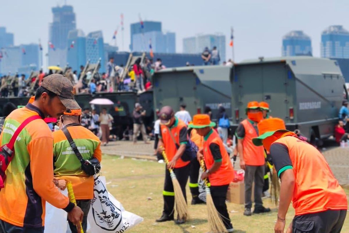 Petugas memunguti sampah pasca HUT TNI di Monas. 