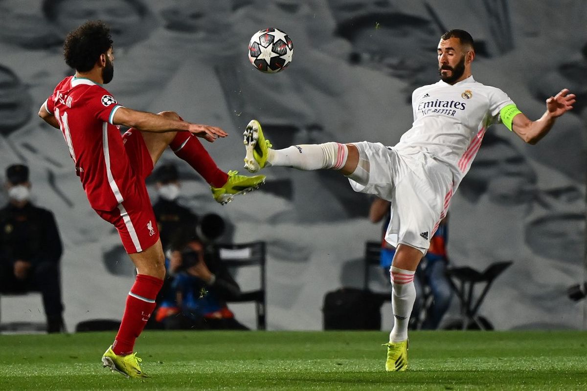 Mohamed Salah (kiri) dan Karim Benzema (kanan) berebut bola dalam pertandingan Real Madrid vs Liverpool di leg pertama perempat final Liga Champions 2020-2021 di Stadion Alfredo Di Stefano, Rabu (7/4/2021) dini hari WIB. 