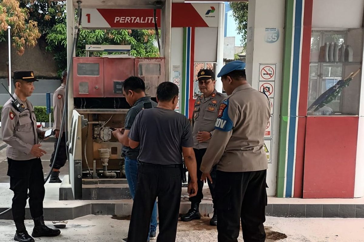 Petugas kepolisian saat mengecek mesin pompa yang terbakar di Stasiun Pengisian Bahan Bakar Umum (SPBU) Jalan Bintaro Permai, Pesanggrahan, Jakarta Selatan, Rabu (26/7/2023).