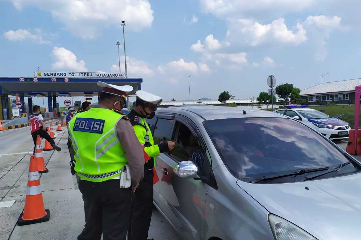 Petugas Ditlantas Polda Lampung memeriksa kelengkapan syarat perjalanan bagi pengendara di Jalan Tol Lampung.