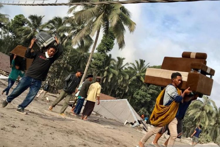 Sejumlah warga Kampung Renteng, Desa Sumberwuluh, Lumajang, saat mengamankan barang-barangnya dari dalam rumah ke tempat lebih aman, Minggu (5/12/2021).