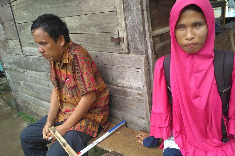 Setiawan (36) dan Kamel Putri (21) pasutri tunanetra di Bandar Lampung berisitirahat dalam perjalanan pulang setelah berkeliling berjualan keripik, Selasa (11/2/2020). Keduanya memutuskan berjualan bersama-sama agar bisa saling menjaga.