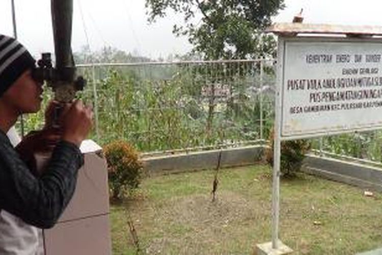 Warga di Pos Pengamatan Gunung Slamet di Desa Gambuhan, Pulosari, Pemalang, Jawa Tengah, menggunakan teropong mengamati Gunung Slamet.  

