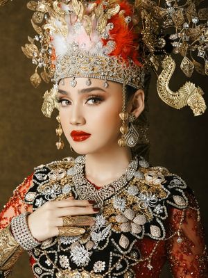 Syifa Hadju dan El Rumi tampil serba merah dalam busana adat Gorontalo saat prewedding. Detail mahkota hingga ornamen emas jadi sorotan.