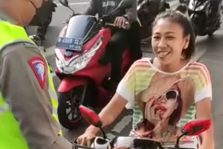Seorang perempuan pengendara motor ditegur oleh polisi karena berkendara tak menggunakan helm saat melintas di Jalan Buncit Raya, Duren Tiga, Pancoran, Jakarta Selatan, Selasa (22/11/22) pagi.