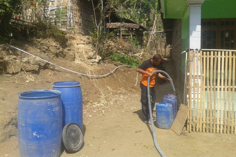 Petugas Badan Penanggulangan Bencana Daerah Kabupaten Ponorogo mengisi tandon air bersih di desa yang mengalami krisis air bersih.