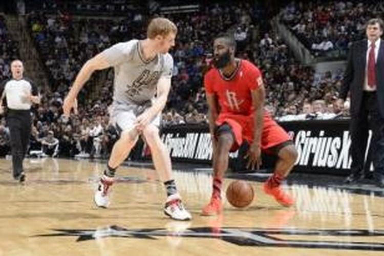 Pemain Houston Rockets, James Harden (kanan) mendribble bola di bawah penjagaan San Antonio Spurs, pada pertandingan lanjutan NBA 2013-2014, di AT&T Center, San Antonio, Rabu (25/12/2013).